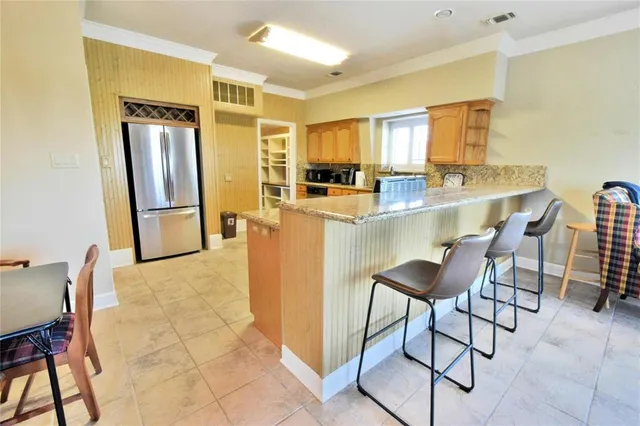 a kitchen with stainless steel appliances granite countertop a stove a sink a oven with a dining table and chairs