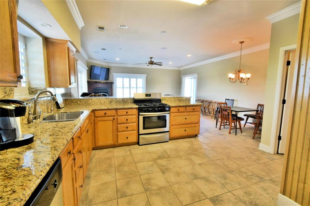 108 Barham Lane Bridgeport, TX 76426 - Photo 17 of 30 a kitchen with stainless steel appliances granite countertop a stove a sink a oven with a dining table and chairs