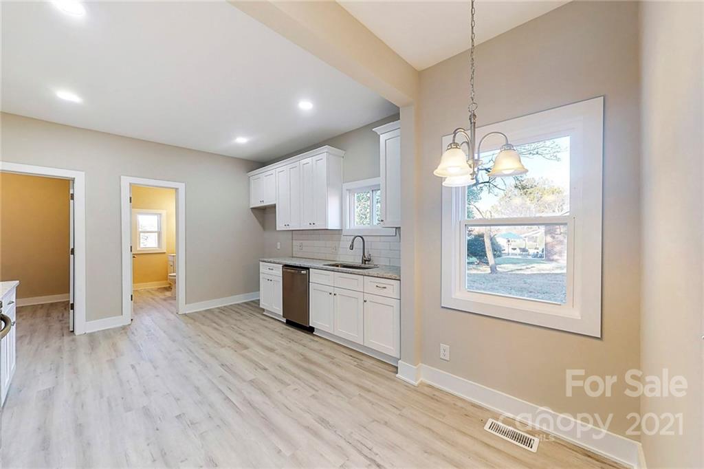 313 Old Williams Road Wingate, NC 28174 - Photo 13 of 46 a large kitchen with kitchen island white cabinets and wooden floor