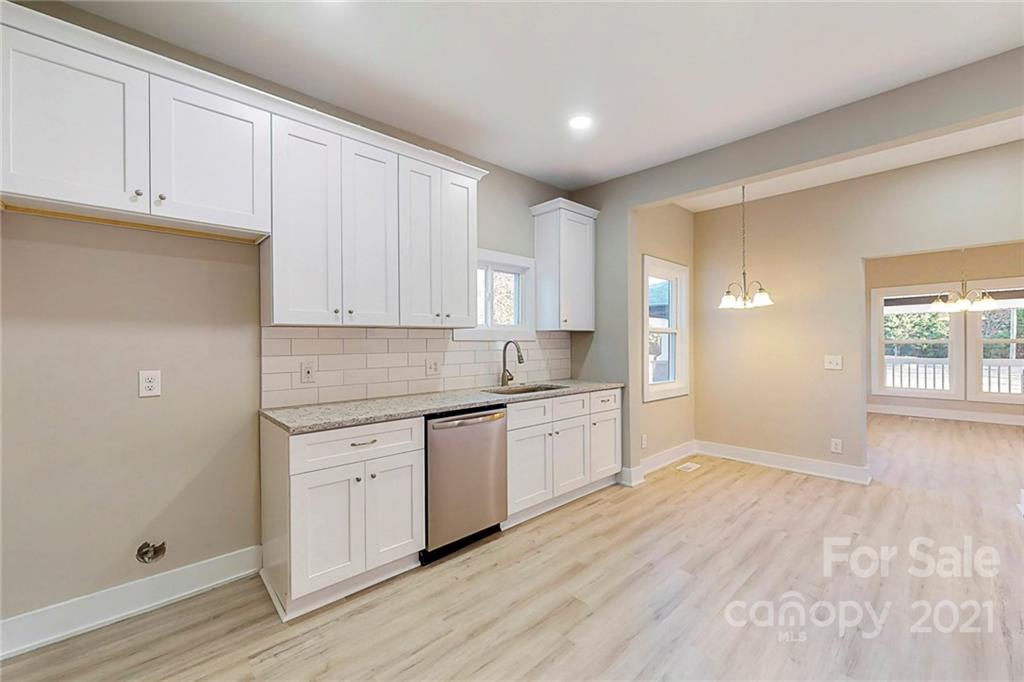 313 Old Williams Road Wingate, NC 28174 - Photo 14 of 46 a large kitchen with granite countertop white cabinets and white appliances