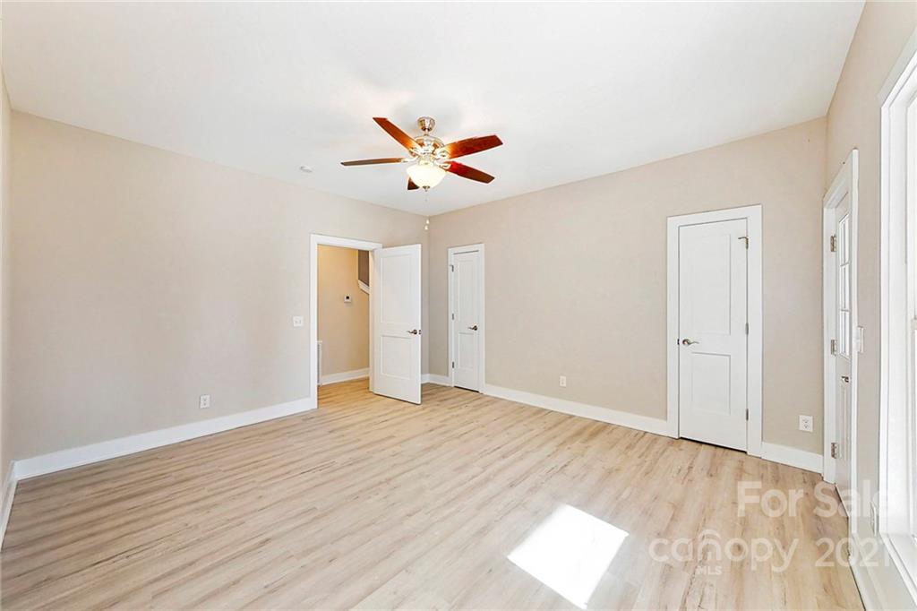 313 Old Williams Road Wingate, NC 28174 - Photo 15 of 46 an empty room with wooden floor and ceiling fan