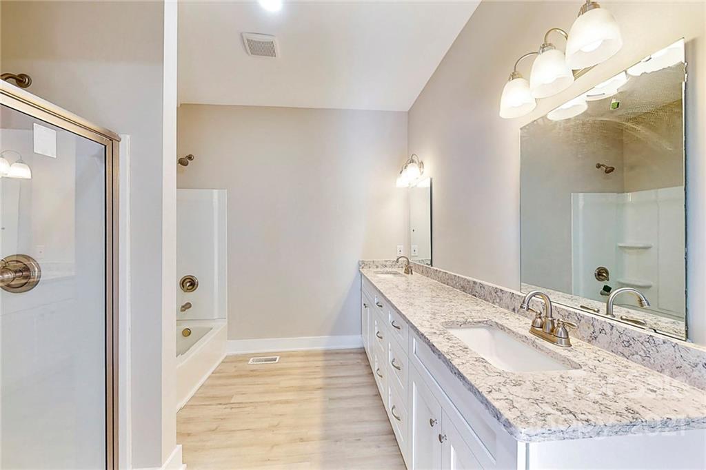 313 Old Williams Road Wingate, NC 28174 - Photo 20 of 46 a spacious bathroom with a granite countertop double vanity sink a mirror and a shower