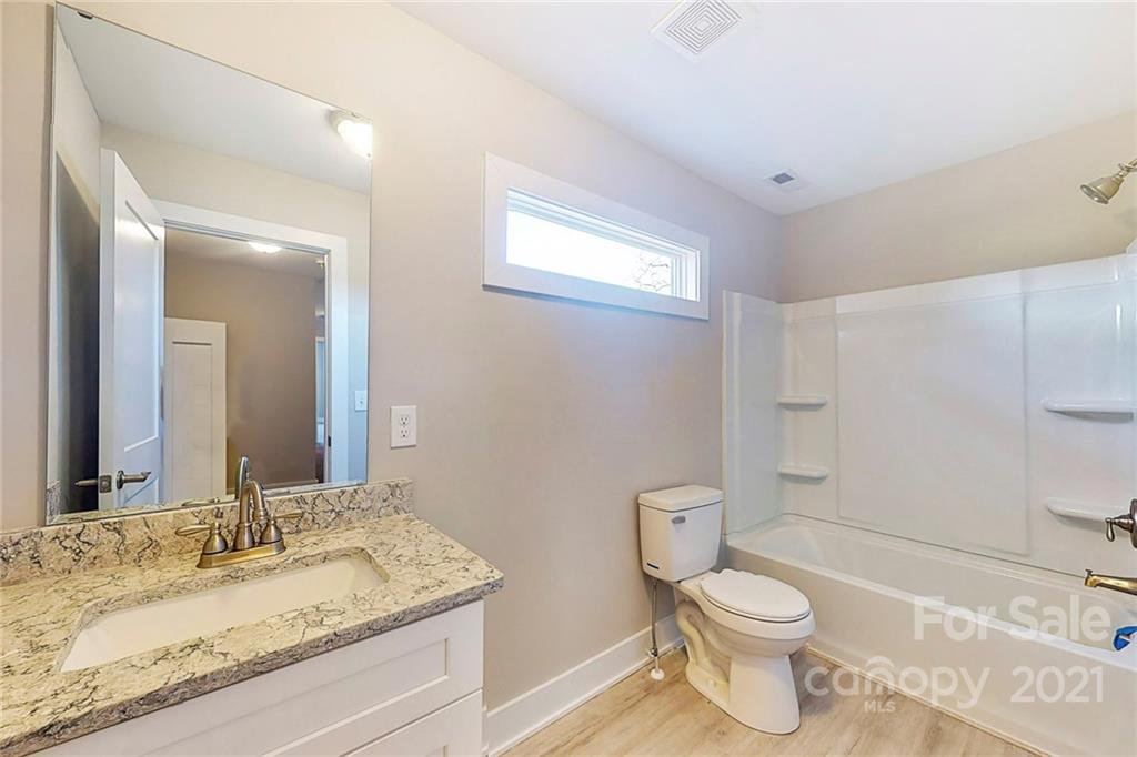 313 Old Williams Road Wingate, NC 28174 - Photo 30 of 46 a bathroom with a granite countertop sink a toilet and a mirror