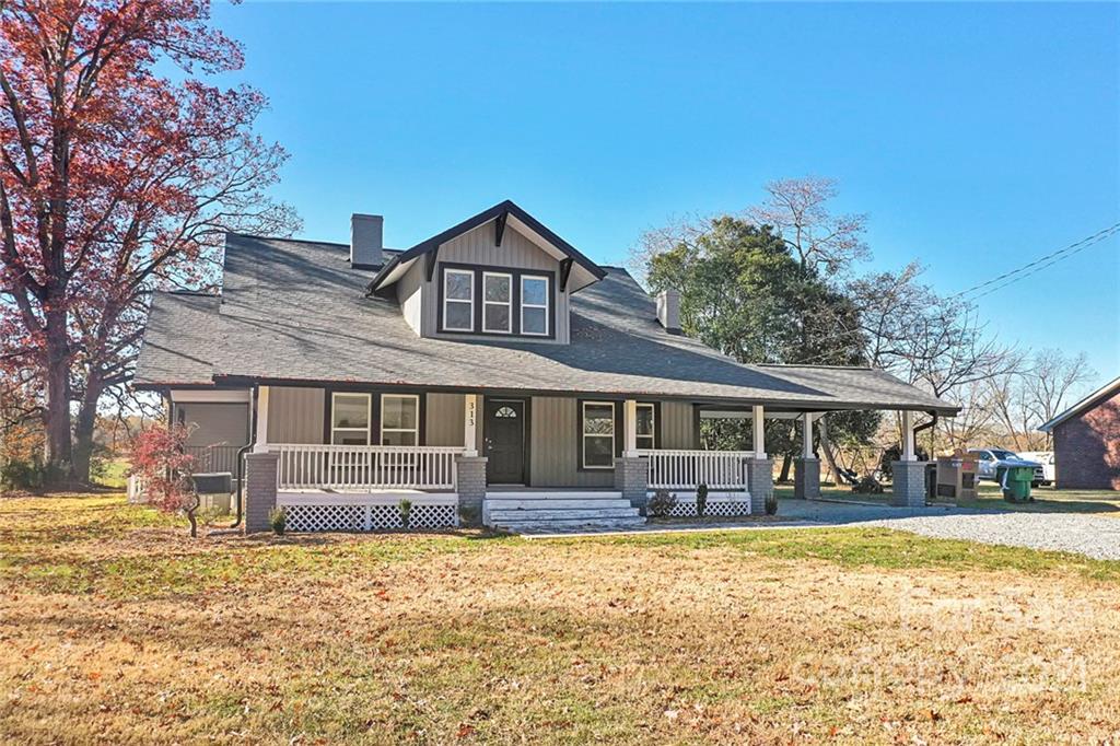 313 Old Williams Road Wingate, NC 28174 - Photo 5 of 46 a front view of a house with a yard covered with snow and trees