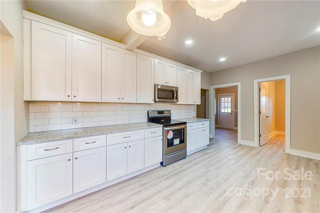 313 Old Williams Road Wingate, NC 28174 - Photo 8 of 46 a kitchen with granite countertop white cabinets and stainless steel appliances