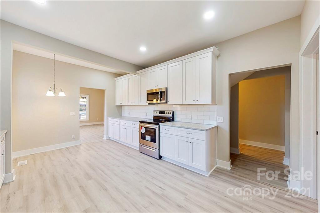 313 Old Williams Road Wingate, NC 28174 - Photo 9 of 46 a large kitchen with cabinets wooden floor and stainless steel appliances