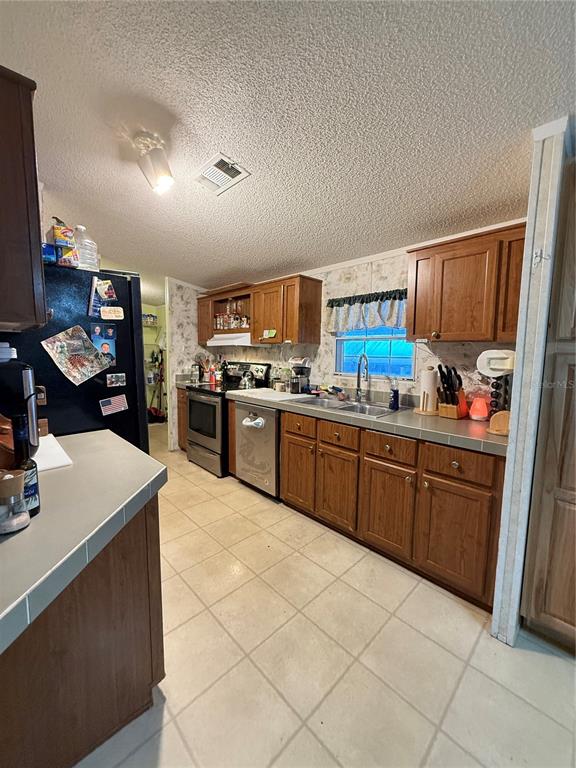 5109 Southwest 10th Street Bell, FL 32619 - Photo 2 of 38 a kitchen with stainless steel appliances granite countertop a sink dishwasher stove top oven and cabinets