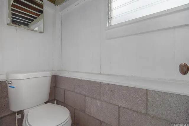 a white toilet sitting next to a shower