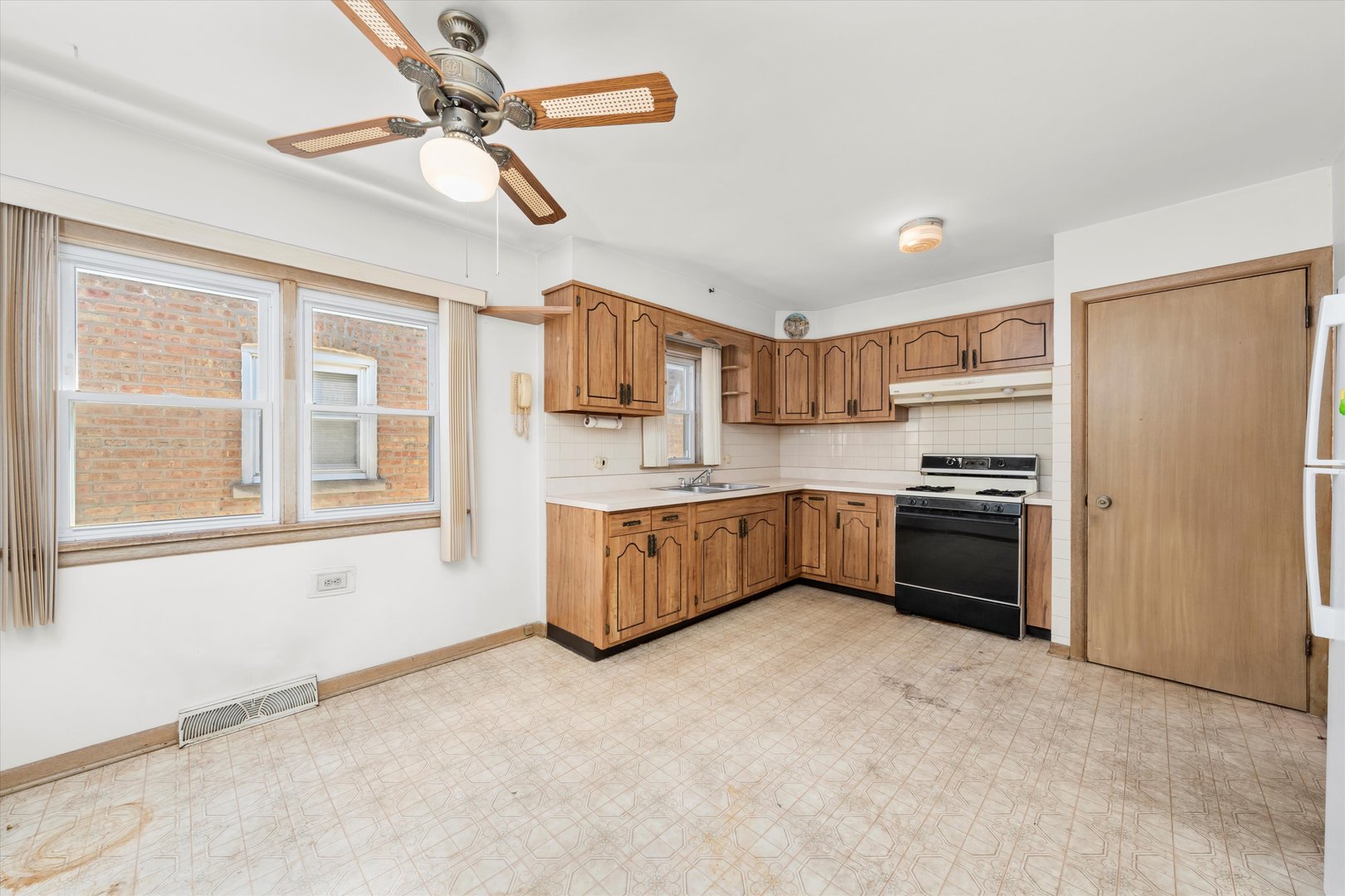 6511 West 63rd Place Chicago, IL 60638 - Photo 4 of 12 a kitchen with a refrigerator a sink and a stove top oven