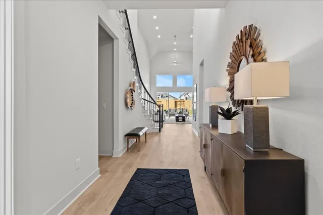 a hallway with a view of living room with wooden floor