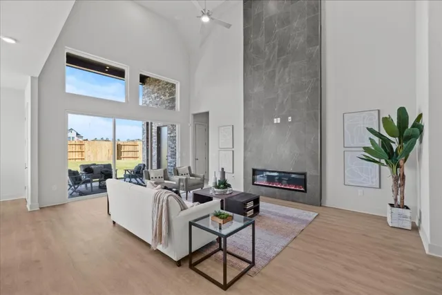 a living room with furniture a potted plant and a large window