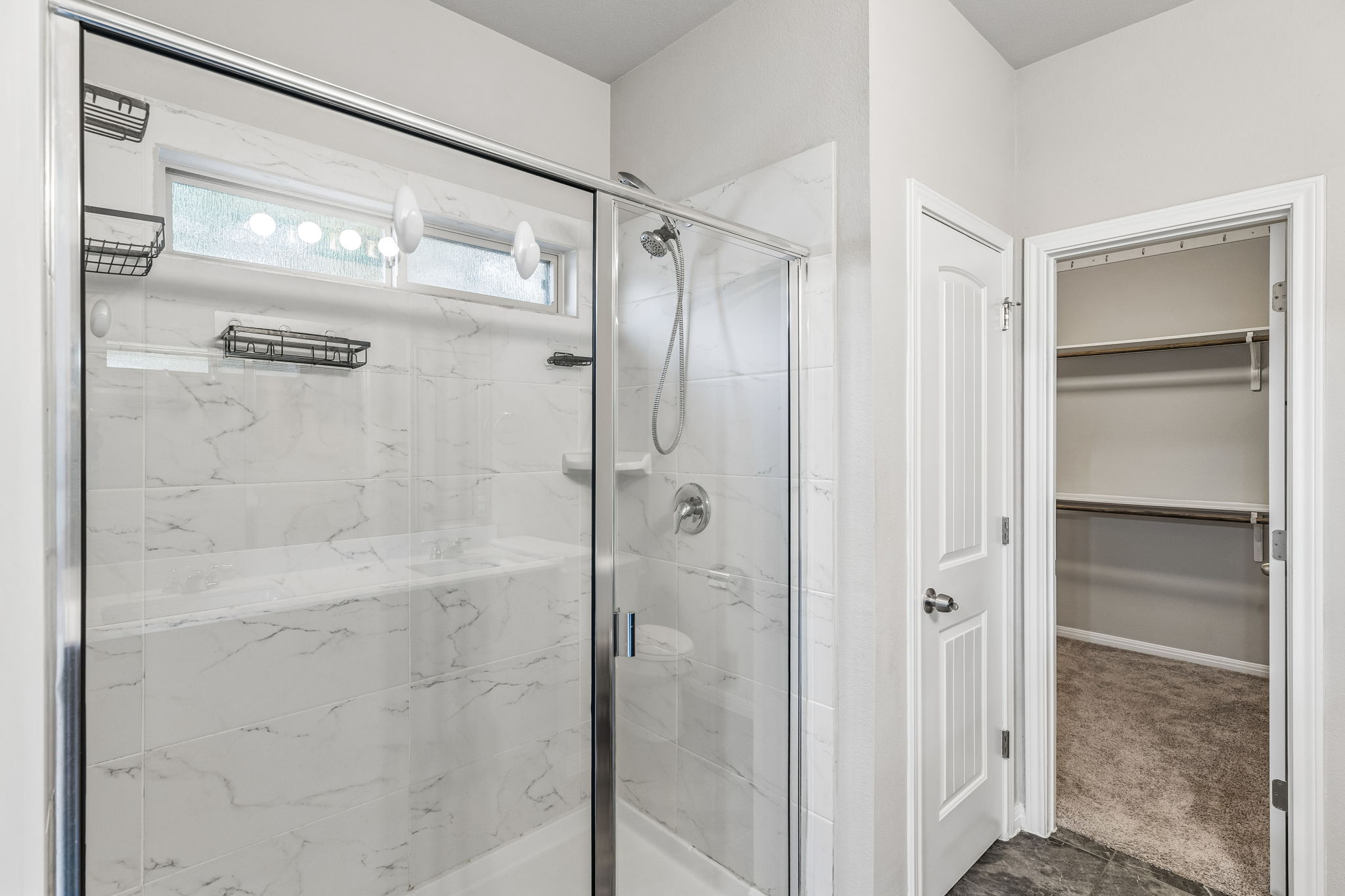 689 Nautical Loop Kyle, TX 78640 - Photo 18 of 34 A well-appointed shower stall features white marble-look tile, glass enclosure, and a convenient high window for natural light.
