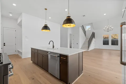 a view of an empty room with wooden floor fireplace and a window