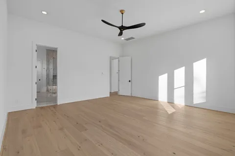 a view of wooden floor and a ceiling fan in a room