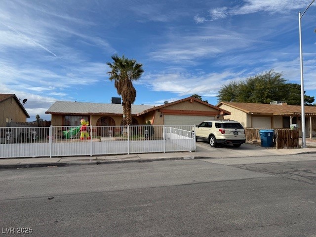 3631 Briarcliff Road Las Vegas, NV 89115 - Photo 2 of 15 Ranch-style home with a fenced front yard, driveway, a garage, and stucco siding