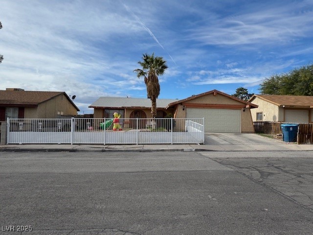 3631 Briarcliff Road Las Vegas, NV 89115 - Photo 9 of 15 Single story home featuring a fenced front yard, concrete driveway, a garage, and stucco siding