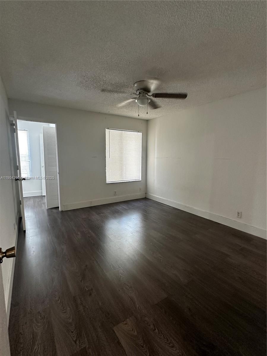 3360 Pinewalk Drive North, Unit 1325 Margate, FL 33063 - Photo 12 of 16 an empty room with wooden floor and windows