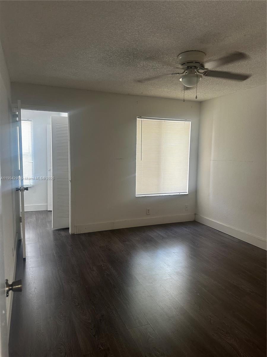 3360 Pinewalk Drive North, Unit 1325 Margate, FL 33063 - Photo 13 of 16 an empty room with wooden floor and windows