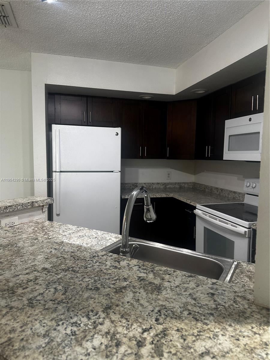3360 Pinewalk Drive North, Unit 1325 Margate, FL 33063 - Photo 2 of 16 a kitchen with a refrigerator stove and cabinets