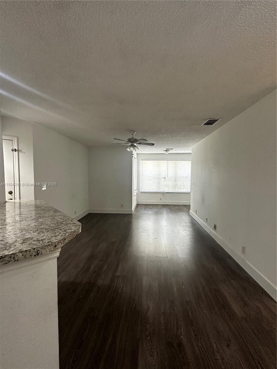 3360 Pinewalk Drive North, Unit 1325 Margate, FL 33063 - Photo 5 of 16 a view of empty room with wooden floor and fan