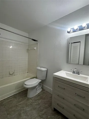 a bathroom with a toilet a sink a mirror and bathtub