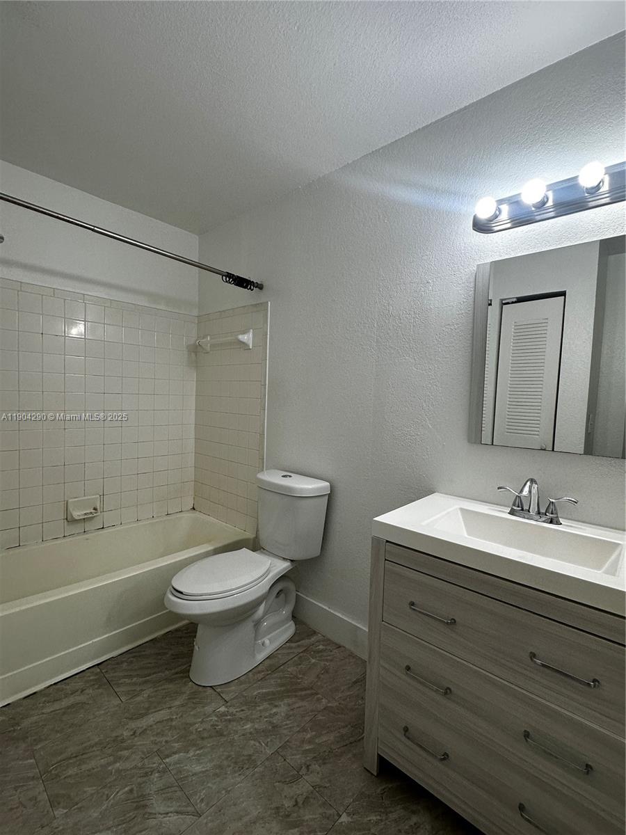 3360 Pinewalk Drive North, Unit 1325 Margate, FL 33063 - Photo 10 of 16 a bathroom with a toilet a sink a mirror and bathtub
