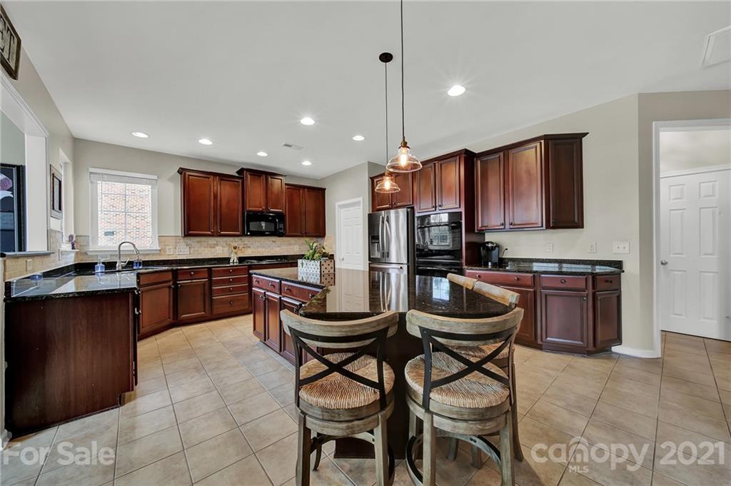 635 Panthers Way Fort Mill, SC 29708 - Photo 17 of 47 a kitchen with stainless steel appliances kitchen island granite countertop a sink and a refrigerator