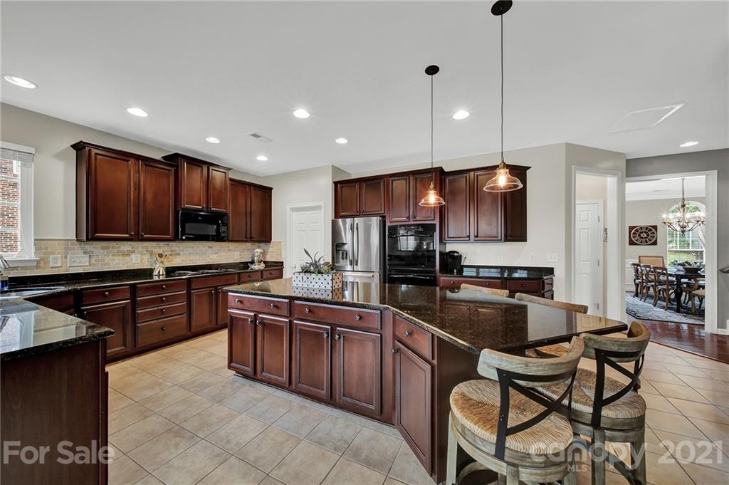 635 Panthers Way Fort Mill, SC 29708 - Photo 18 of 47 a kitchen with stainless steel appliances wooden cabinets granite counter tops a stove a sink and a refrigerator