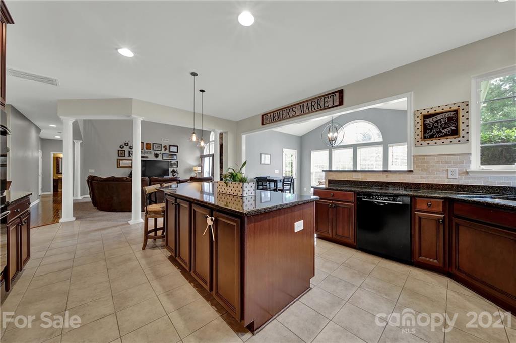 635 Panthers Way Fort Mill, SC 29708 - Photo 19 of 47 a kitchen with stainless steel appliances granite countertop a stove a sink dishwasher a refrigerator and a wooden cabinets