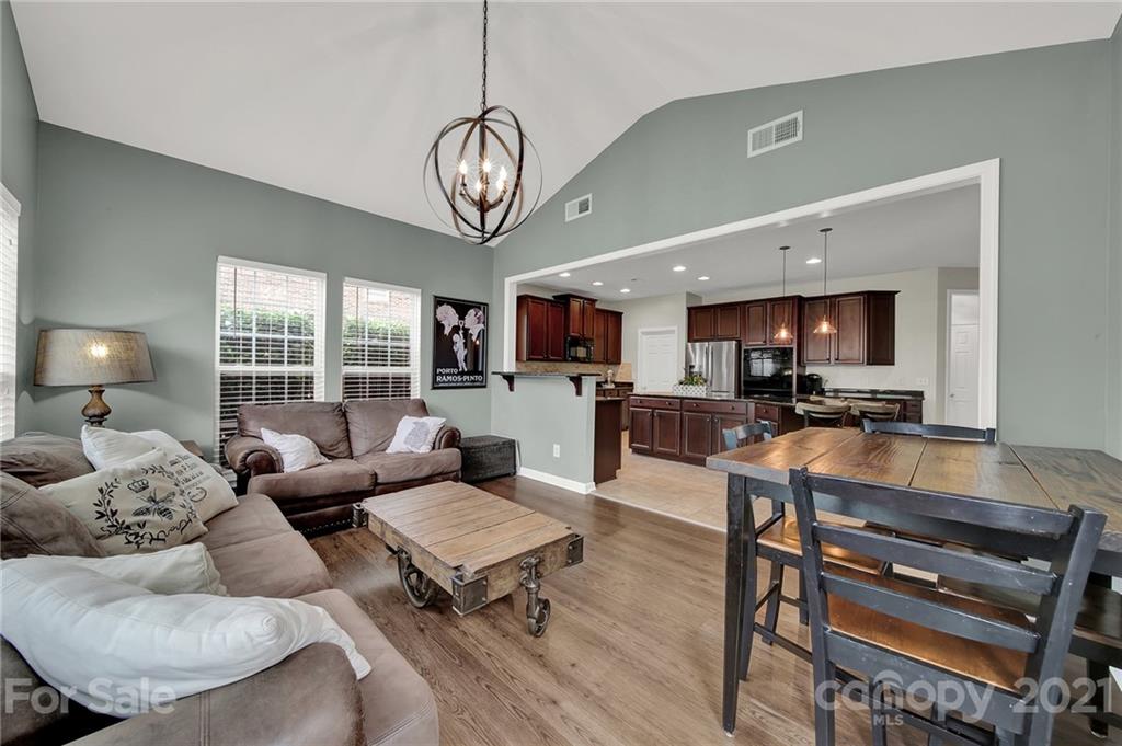 635 Panthers Way Fort Mill, SC 29708 - Photo 23 of 47 a living room with furniture a wooden floor and a chandelier