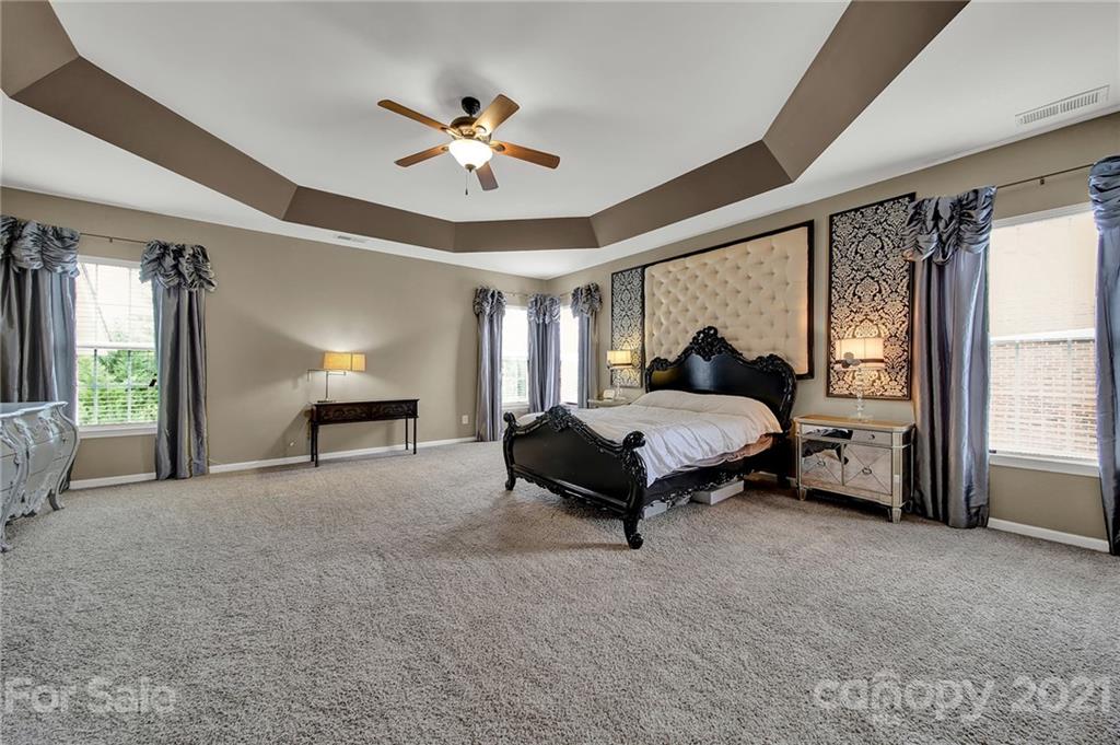635 Panthers Way Fort Mill, SC 29708 - Photo 30 of 47 a spacious bedroom with a bed and a chandelier