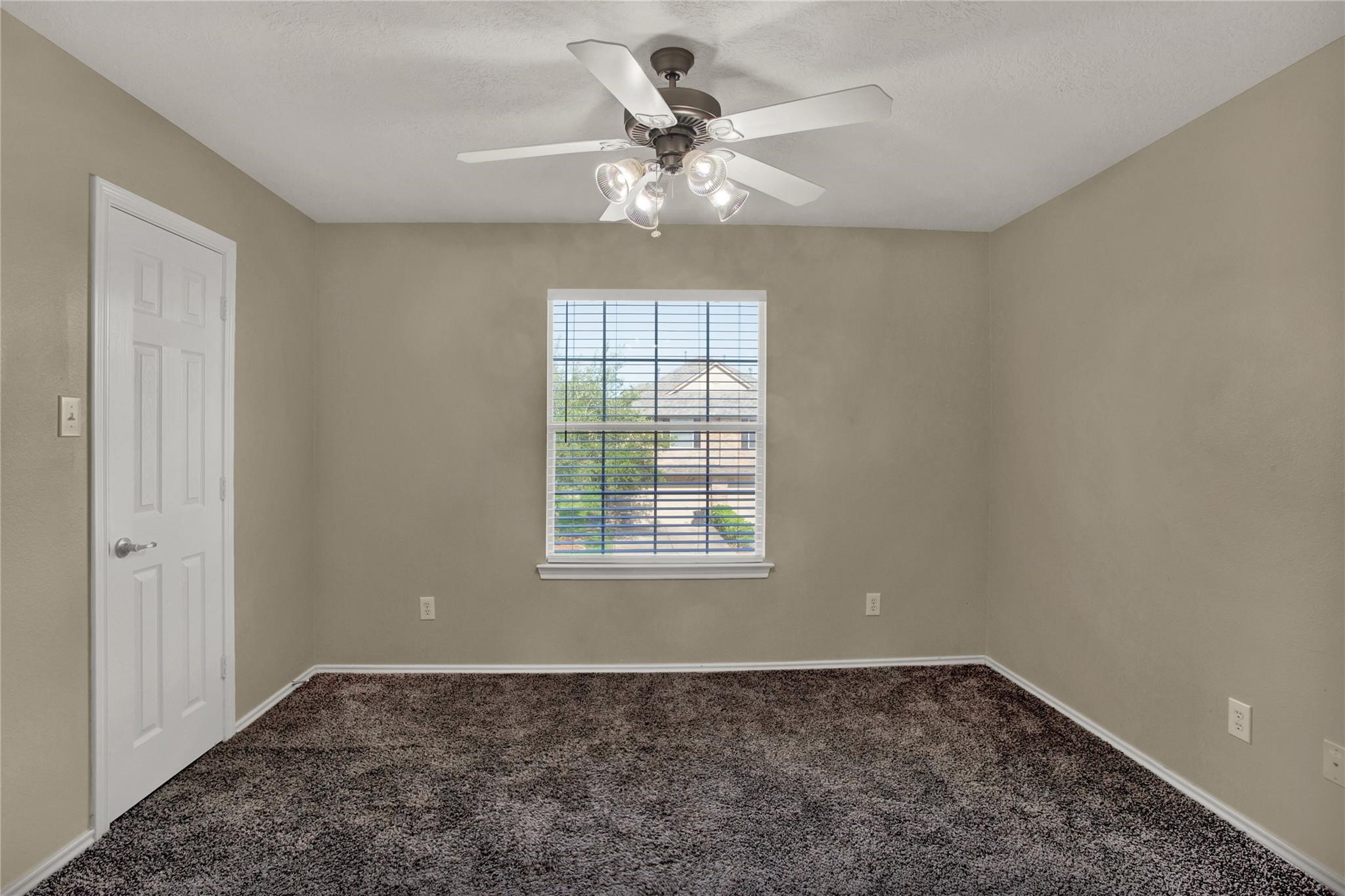 326 Brandy Ridge Lane Dickinson, TX 77539 - Photo 18 of 22 an empty room with a chandelier fan and windows