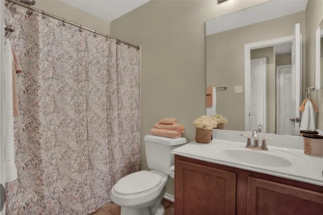 a bathroom with a granite countertop sink a toilet and a mirror