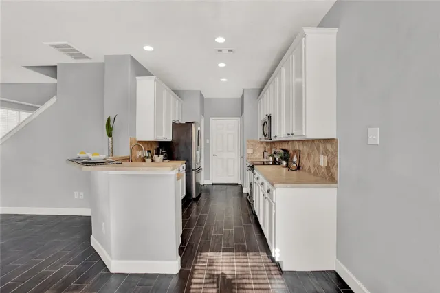 a kitchen with refrigerator and cabinets
