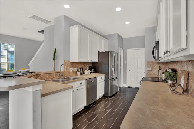 a kitchen with a sink a refrigerator and cabinets