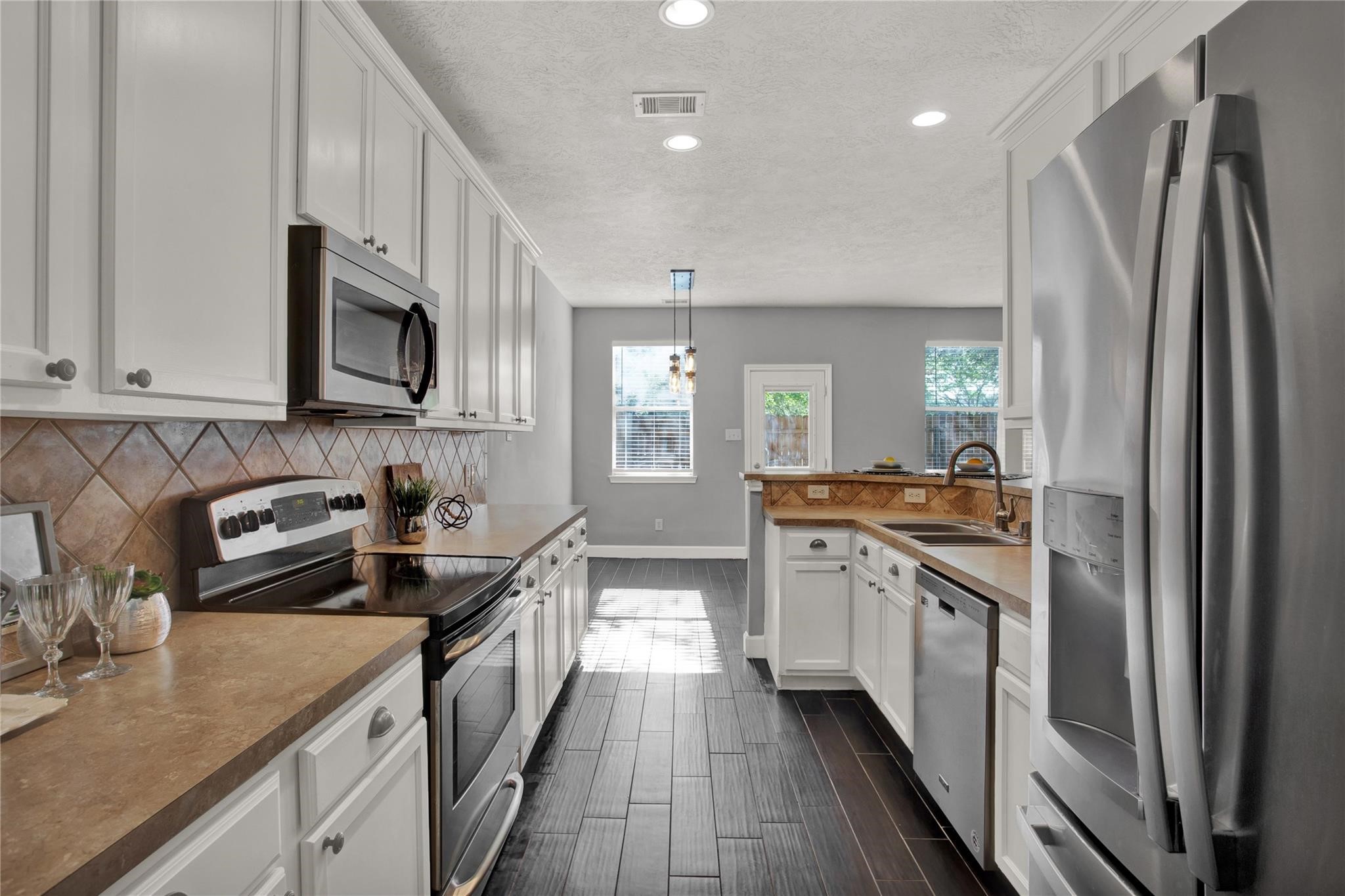 326 Brandy Ridge Lane Dickinson, TX 77539 - Photo 8 of 22 a kitchen with stainless steel appliances granite countertop a refrigerator a stove a sink and a microwave