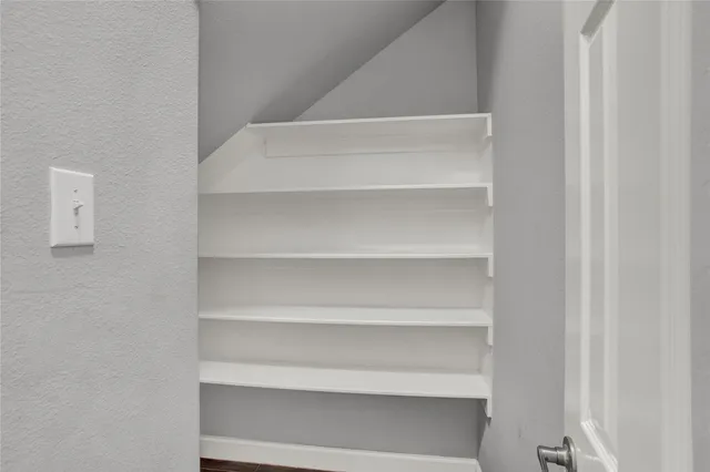 a view of walk in closet with empty racks