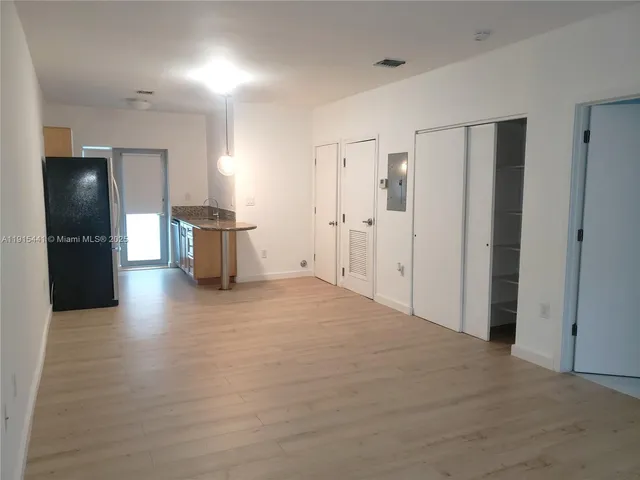 a view of a kitchen with a refrigerator and cabinets