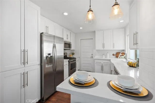 a kitchen with stainless steel appliances granite countertop a refrigerator and a sink