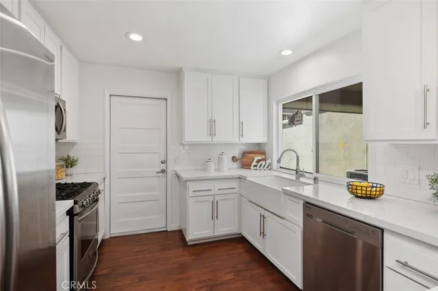 a kitchen with a sink cabinets stainless steel appliances and counter space