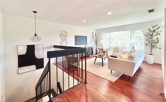 a living room with furniture and a wooden floor