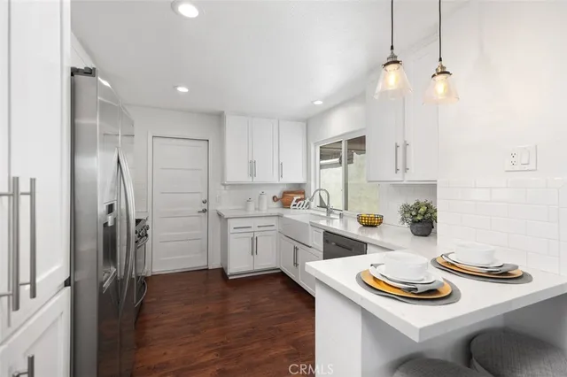 a kitchen with white cabinets and appliances