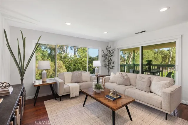 a living room with furniture a flat screen tv and a window