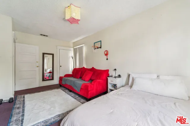 a bedroom with two beds and a chandelier