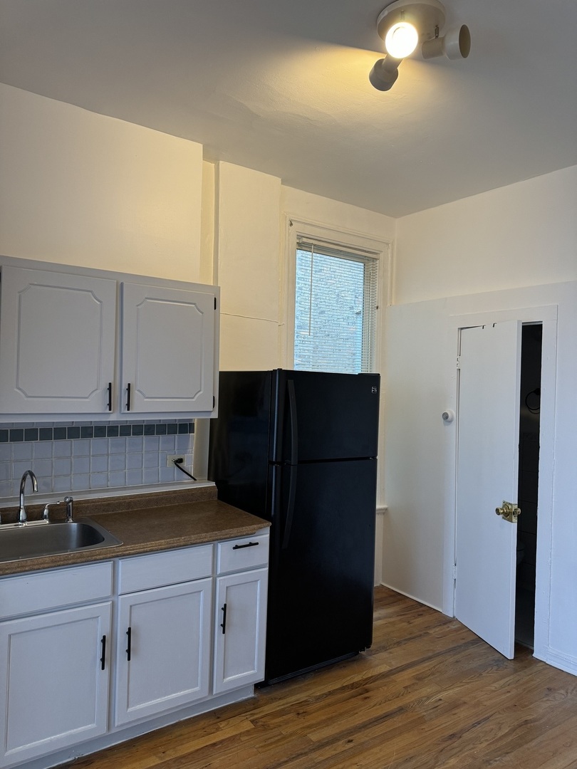 1226 North Artesian Avenue, Unit 2 Chicago, IL 60622 - Photo 7 of 12 a kitchen with a refrigerator and cabinets