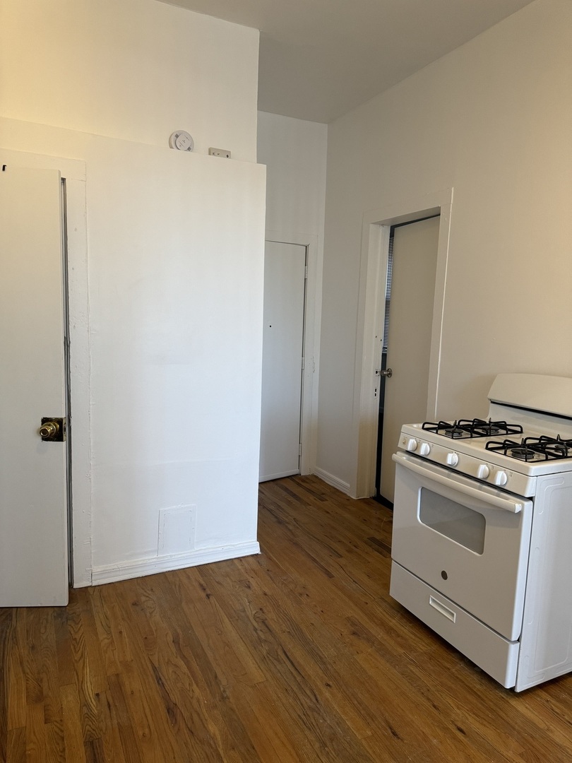1226 North Artesian Avenue, Unit 2 Chicago, IL 60622 - Photo 8 of 12 a view of a kitchen with wooden floor and electronic appliances