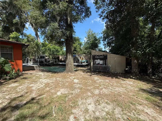 a backyard of a house with fire pit and trees