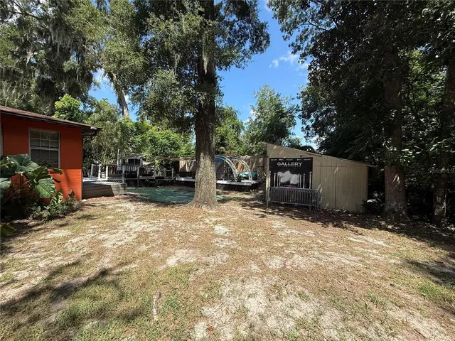 a backyard of a house with barbeque oven and trees