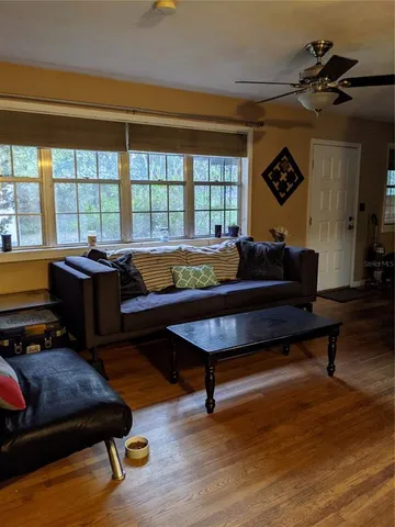 a living room with furniture and a wooden floor