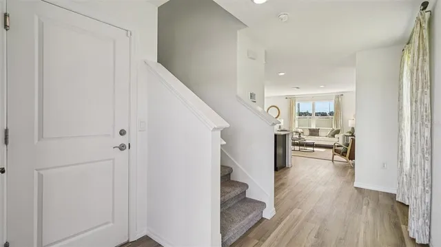 a view of a hallway view with wooden floor and dining room with wooden floor